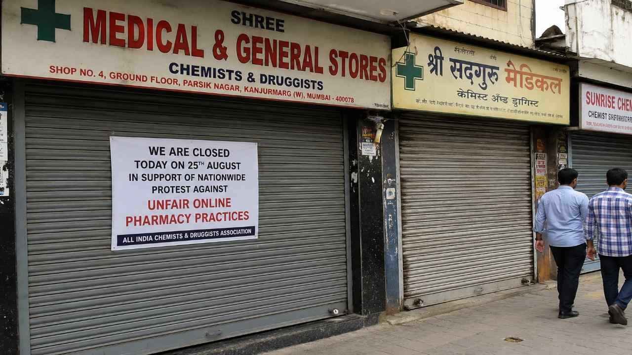 Closed medical shops with protest notice displayed on shutters during a nationwide pharmacy protest in a busy street area.